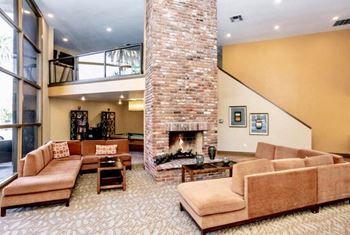 a living room filled with furniture and a large brick fireplace